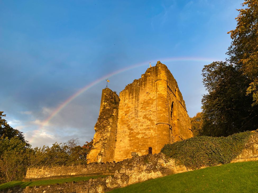 The ruins of a castle with a rainbow overhead at Honeysuckle Lodge in Knaresborough