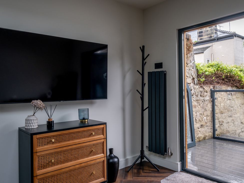A living room with a television and a drawer at Honeysuckle Lodge in Knaresborough