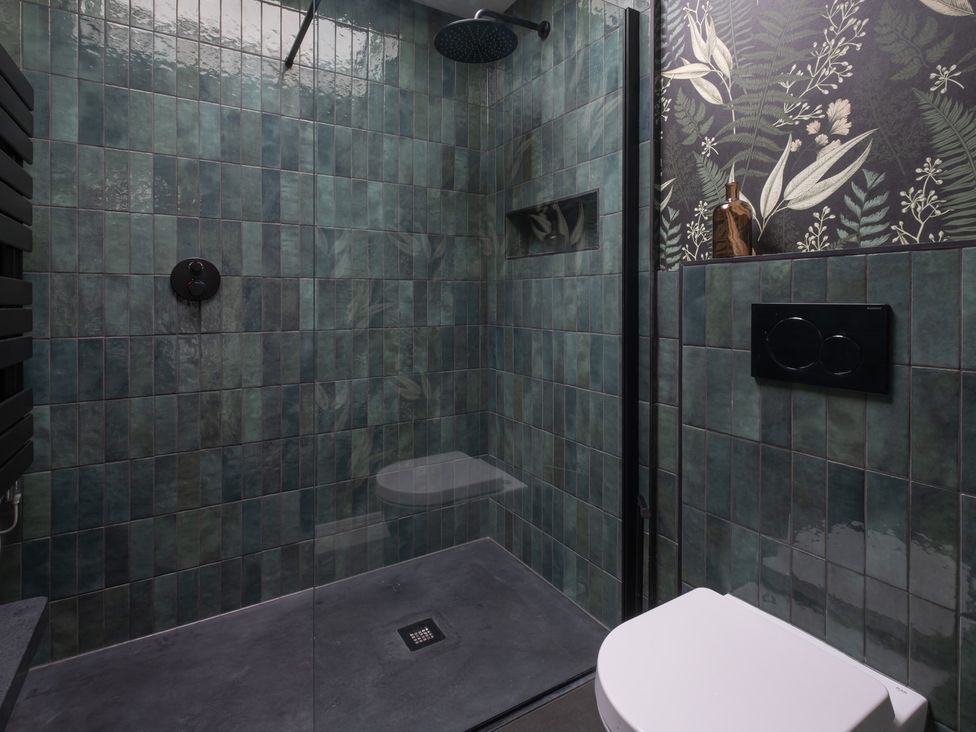 A bathroom with a shower and toilet at Honeysuckle Lodge in Knaresborough