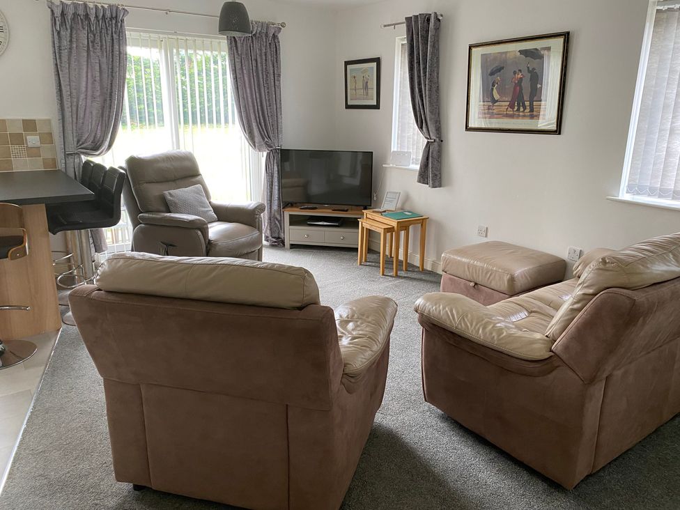 A living room with a sofa and television at 19 Carnaby Mews in Bridlington