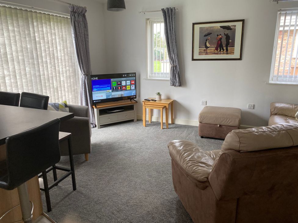 A living room with a television and sofa at 19 Carnaby Mews in Bridlington