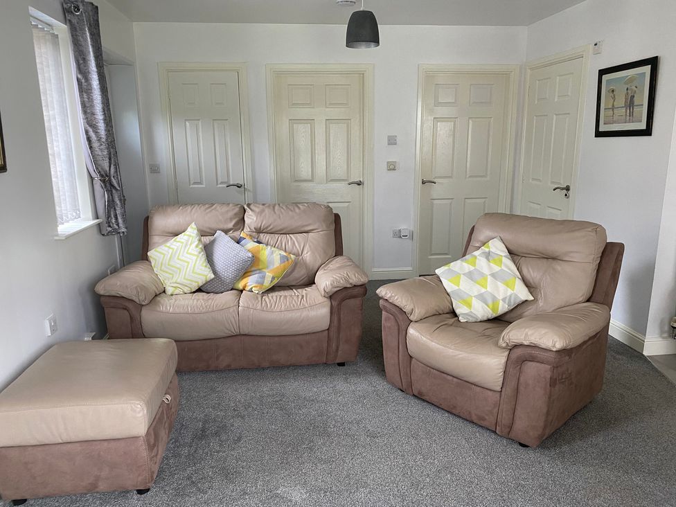 A living room with a sofa and armchair at 19 Carnaby Mews in Bridlington