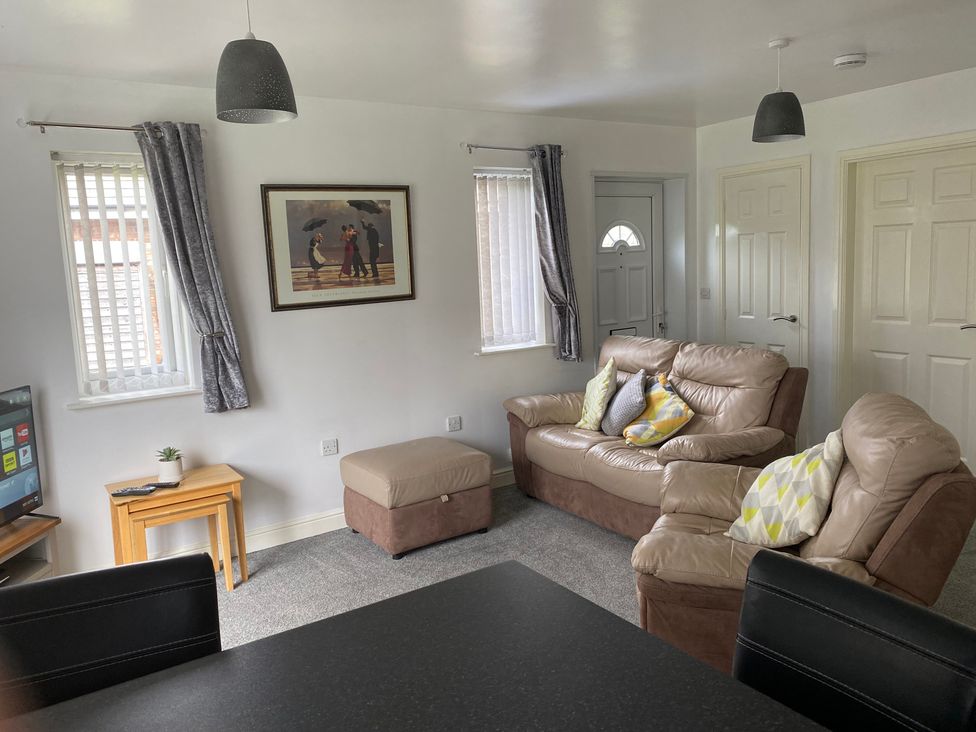 A living room with a sofa and television at 19 Carnaby Mews Bridlington