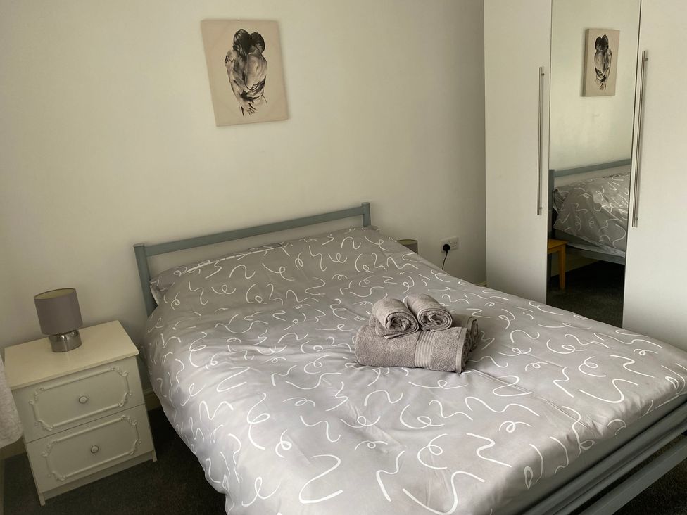 A bedroom with a bed and lamps at 19 Carnaby Mews in Bridlington