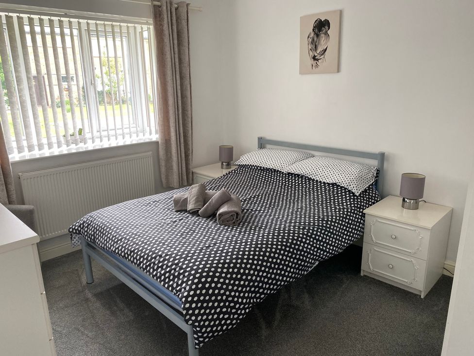 A bedroom with a bed and side tables at 19 Carnaby Mews in Bridlington