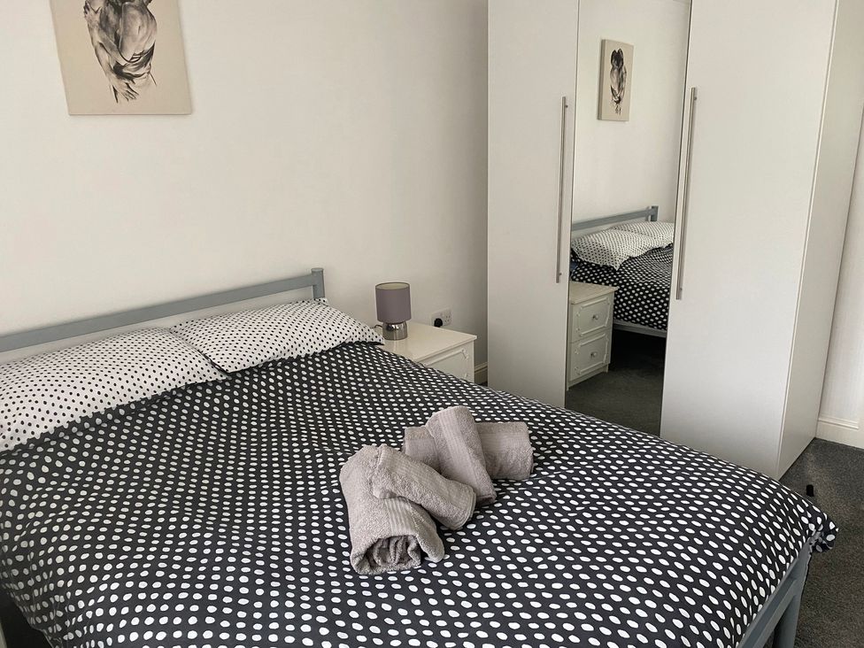 A bedroom with a bed and wardrobe at 19 Carnaby Mews in Bridlington