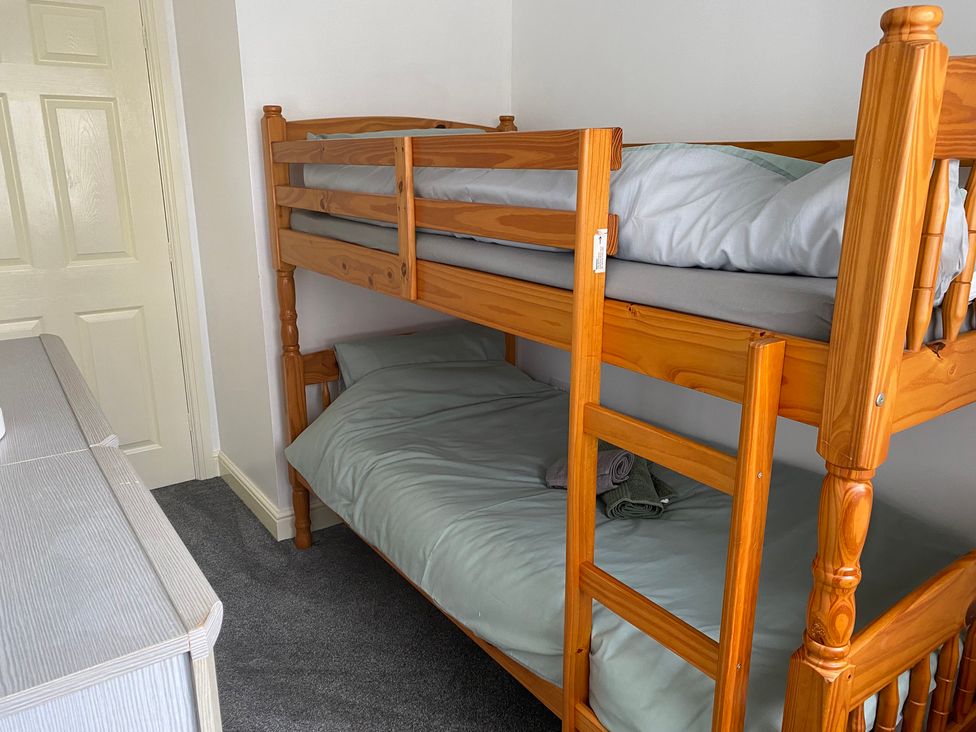 A bedroom with a bunk bed and a dresser at 19 Carnaby Mews in Bridlington