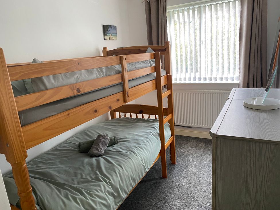 A bedroom with a bunk bed and desk at 19 Carnaby Mews in Bridlington