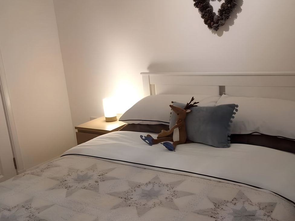 A bedroom with a bed and a decorative pillow at Gowrie Lodge in Blairgowrie