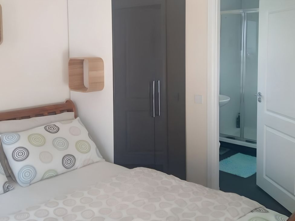 A bedroom with a bed and wardrobe at Gowrie Lodge in Blairgowrie