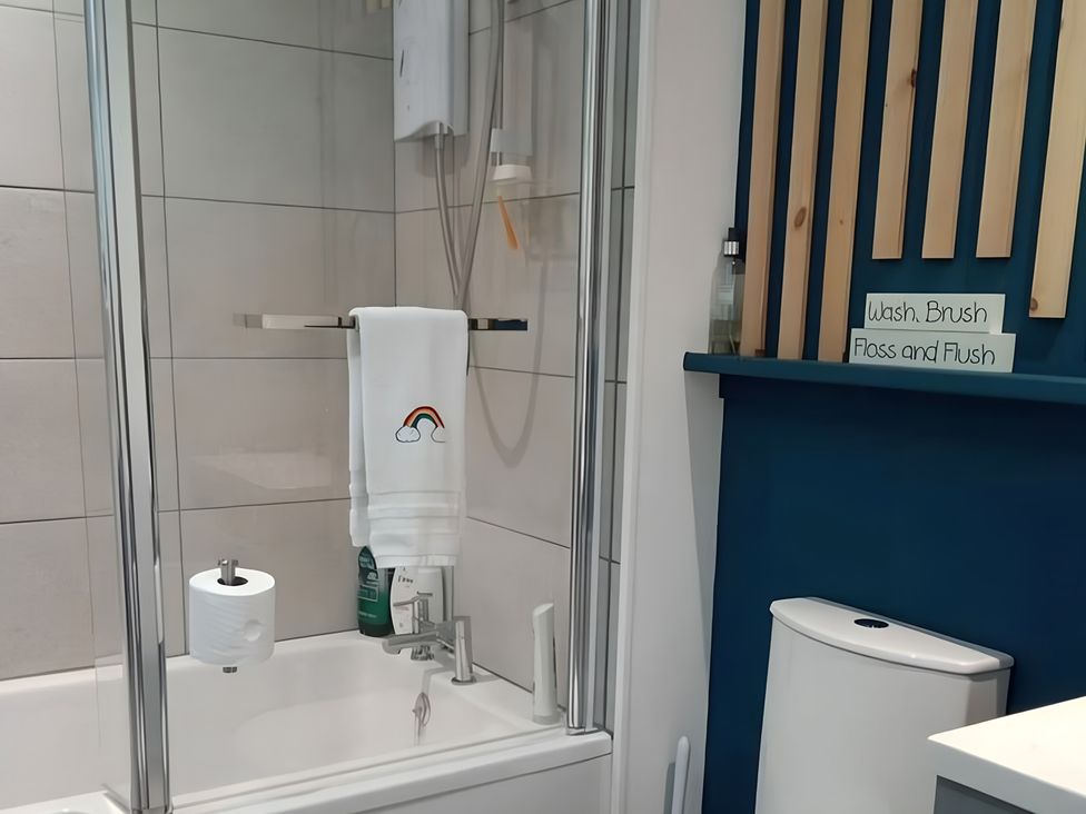 A bathroom with a shower, towel, and toilet at Gowrie Lodge in Blairgowrie