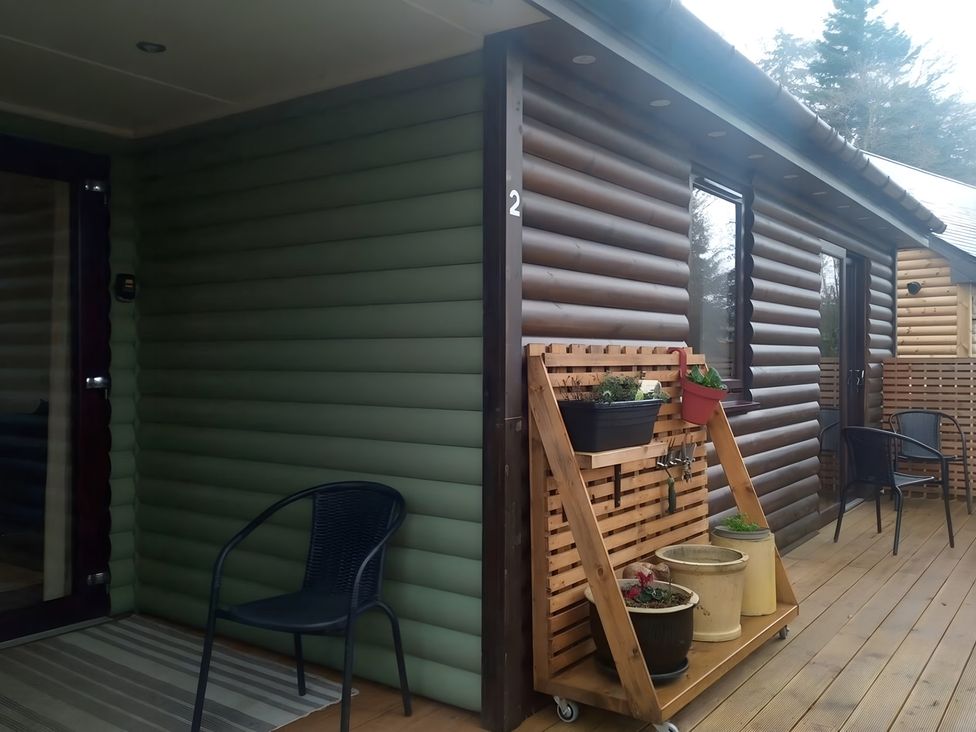 An outdoor area with wooden siding and potted plants at Gowrie Lodge in Blairgowrie