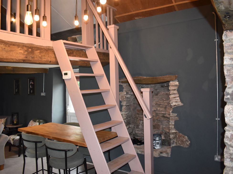 A dining area with stairs and lights at Ty Llaeth in Carmarthen
