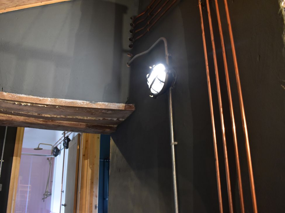 A room with copper pipes and a light fixture at Ty Llaeth in Carmarthen