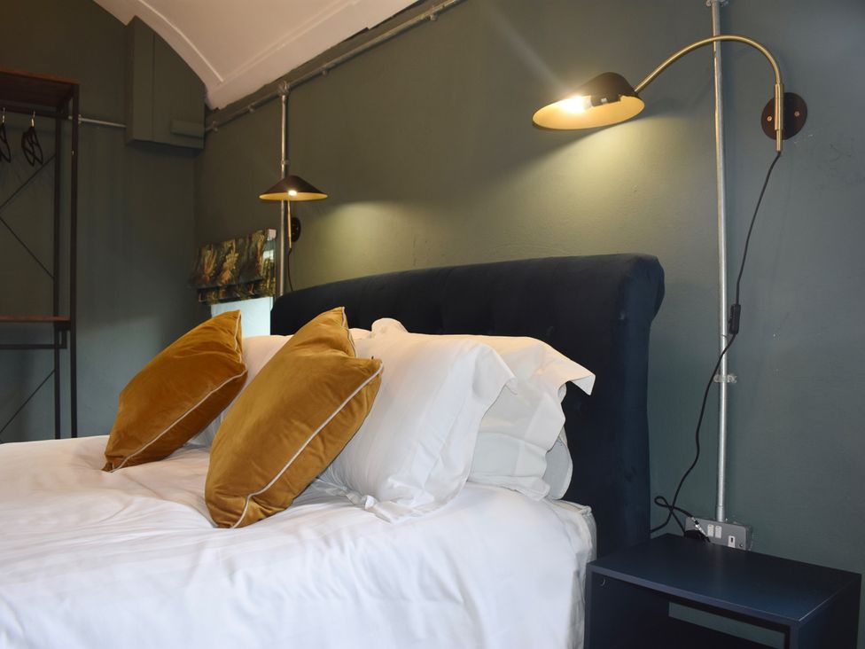 A bedroom with a bed and pillows at Ty Llaeth in Carmarthen