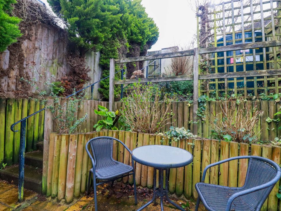 A garden with a table and chairs at 21 Greenwix Parc