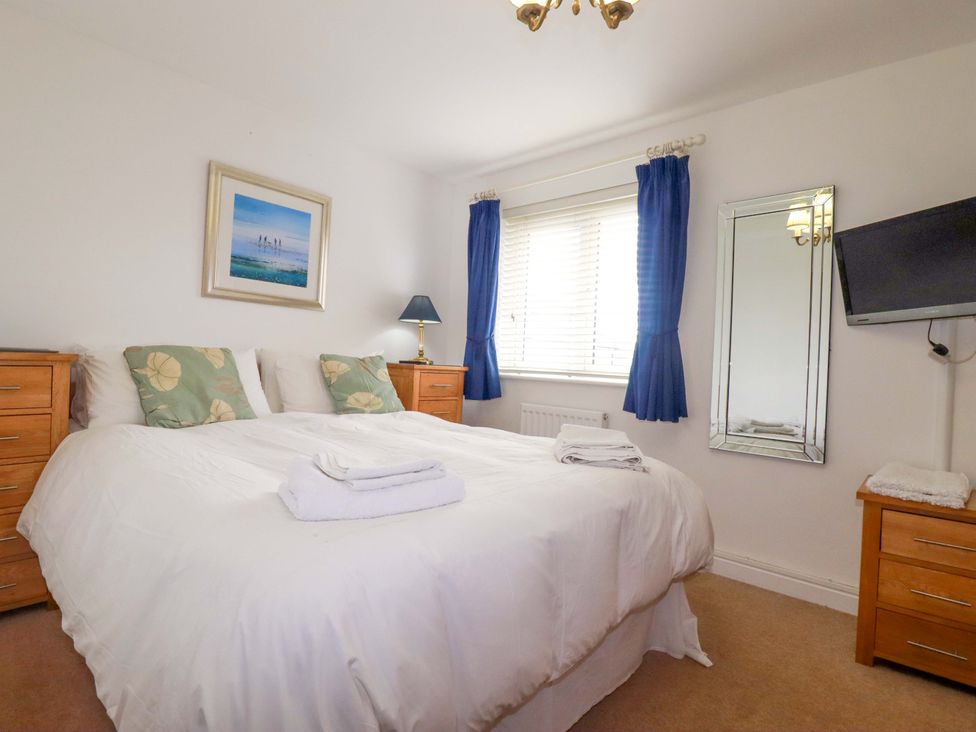 A bedroom with a bed and bedside tables at 21 Greenwix Parc