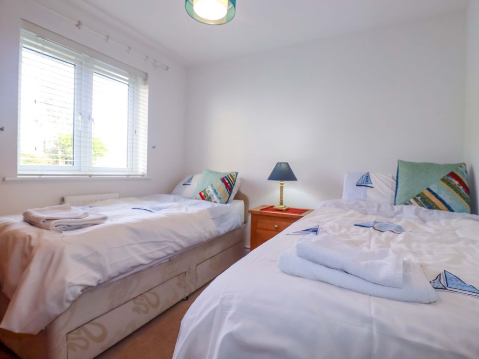 A bedroom with twin beds and a bedside table at 21 Greenwix Parc in 