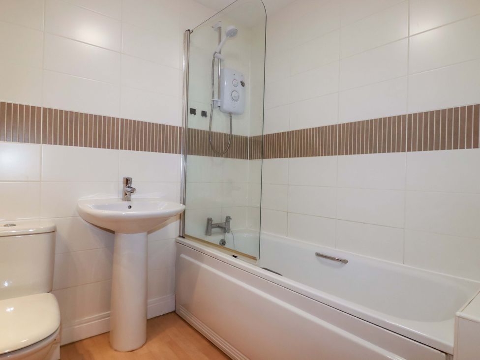 A bathroom with a bathtub, shower, sink, and toilet at 21 Greenwix Parc