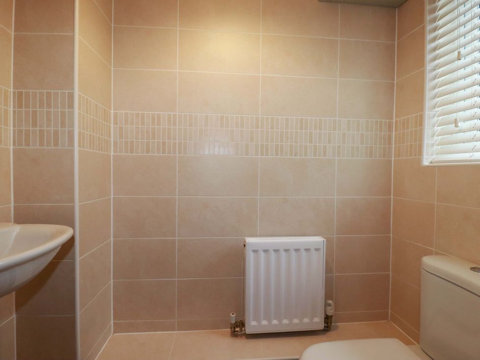 A bathroom with a sink, toilet, and radiator at 21 Greenwix Parc