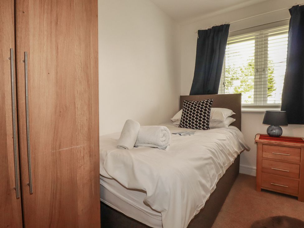 A bedroom with a bed and wardrobe at Treveline in St Mabyn