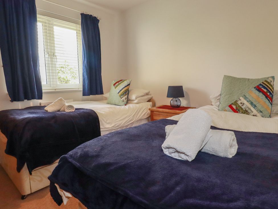 A bedroom with two beds and a lamp at Treveline in St Mabyn
