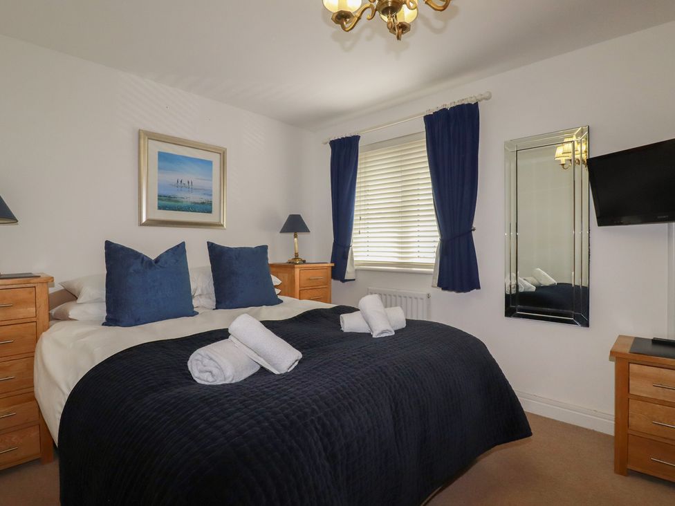 A bedroom with a bed and nightstands at Treveline in St Mabyn