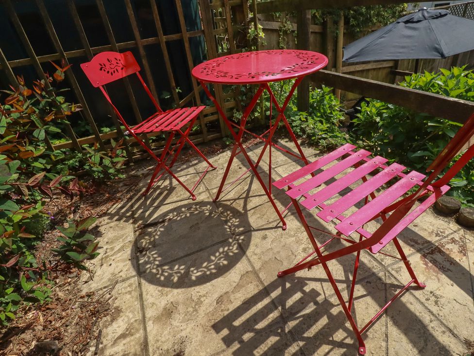 A garden with red furniture and plants at Treveline in St Mabyn