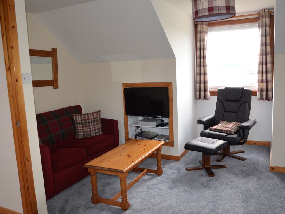 A snug with a sofa, table and chair at Oran Na Mara Achnasheen