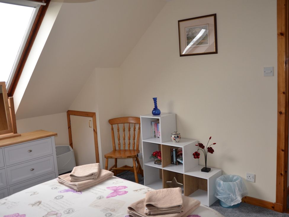 A bedroom with a bed and bookshelf at Oran Na Mara Achnasheen