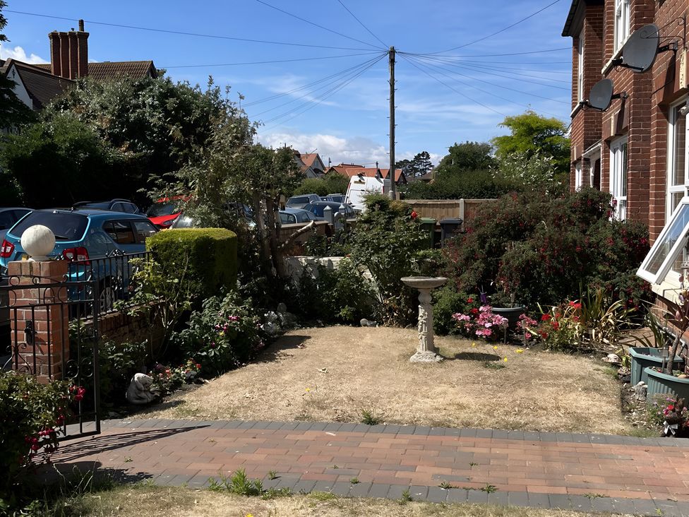 A garden with a birdbath and flower bed at Edal Court in Sheringham