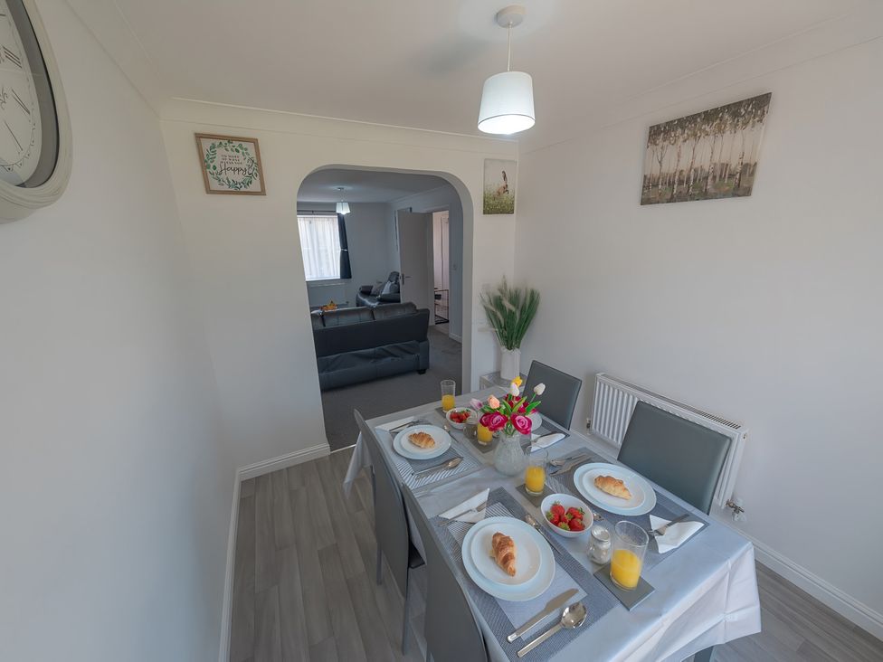 A dining room with a table set for breakfast at Bluebell Close in Corby