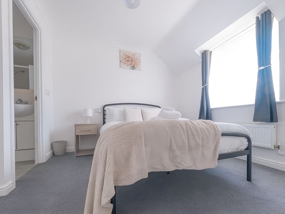 A bedroom with a bed and a bedside table at Bluebell Close in Corby