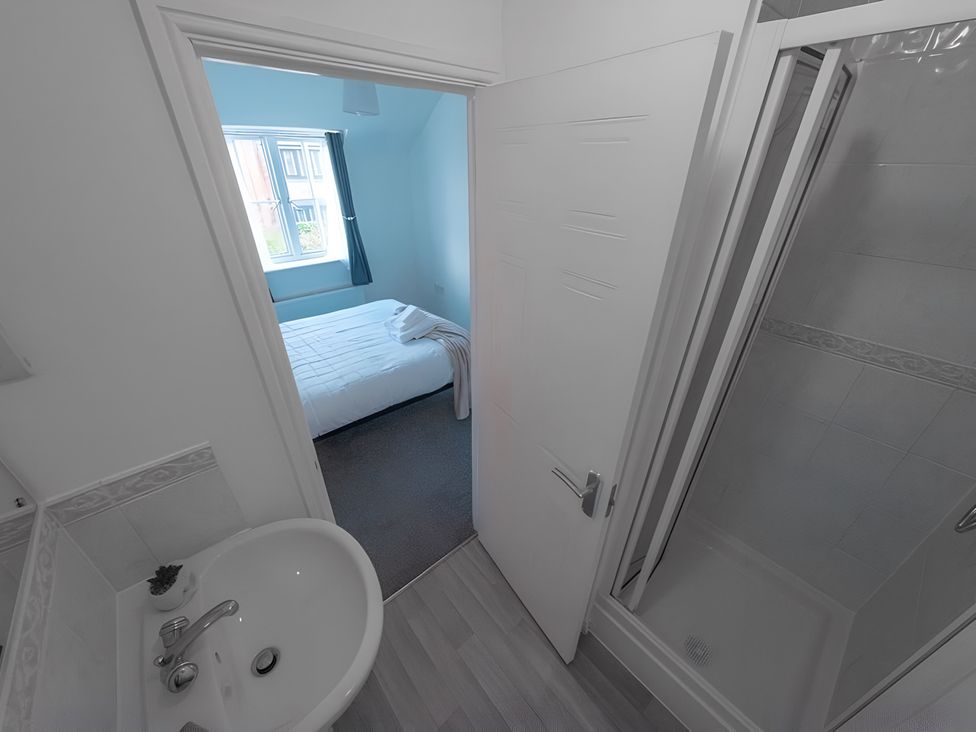 A bathroom with shower and wash basin at Bluebell Close in Corby