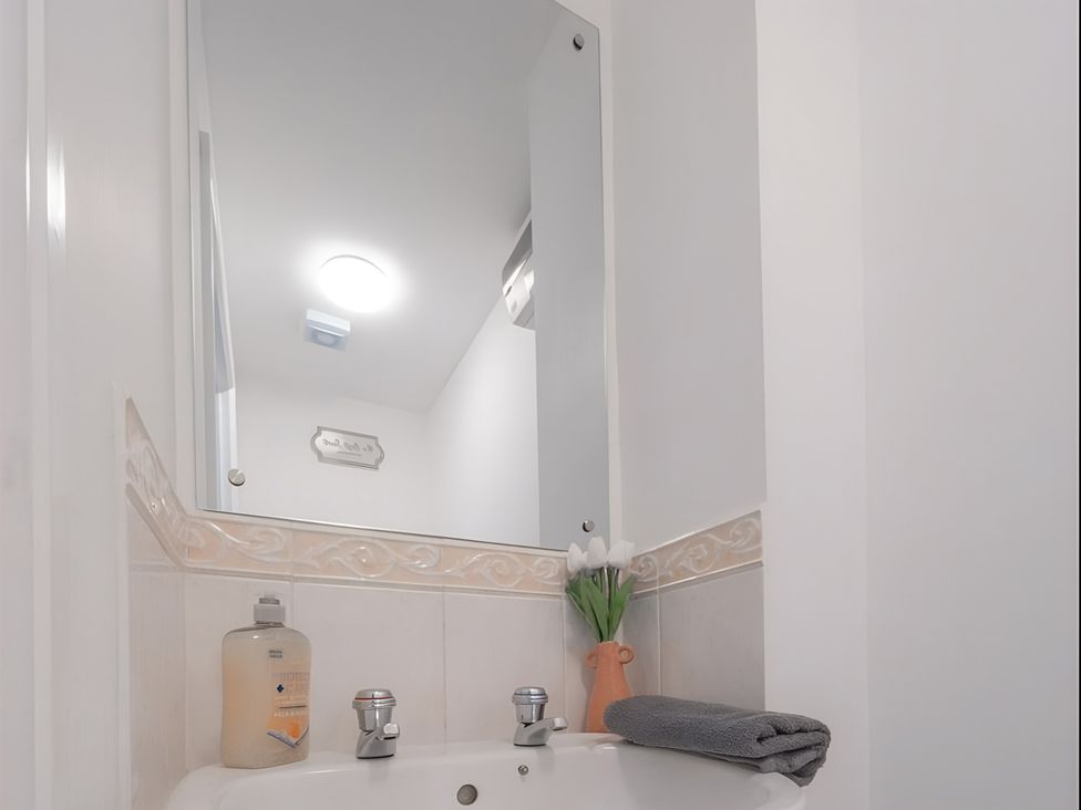 A bathroom with a sink and mirror at Bluebell Close in Corby