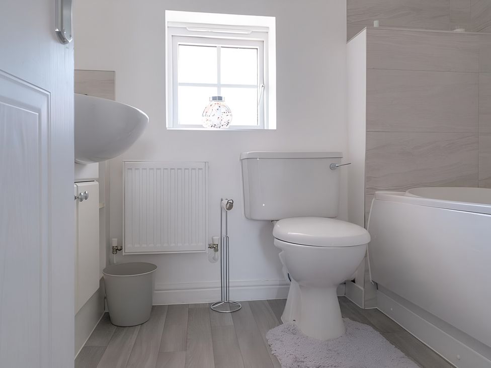 A bathroom with a toilet, sink, and bath tub at Bluebell Close Corby