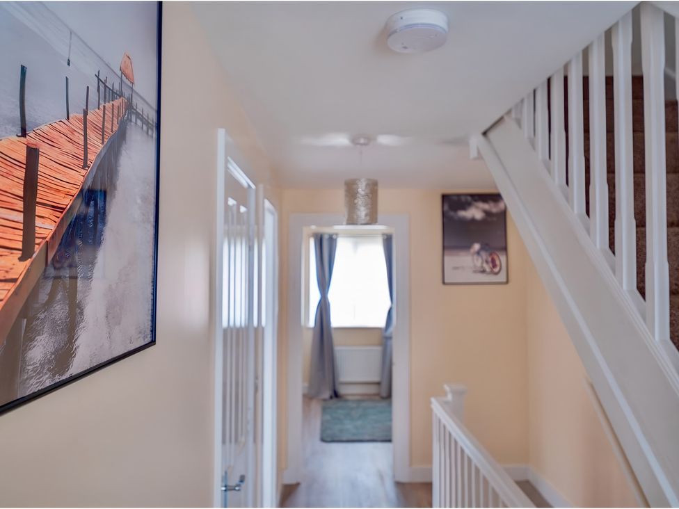 A hallway with stairs and wall art at Rochester Road in Corby