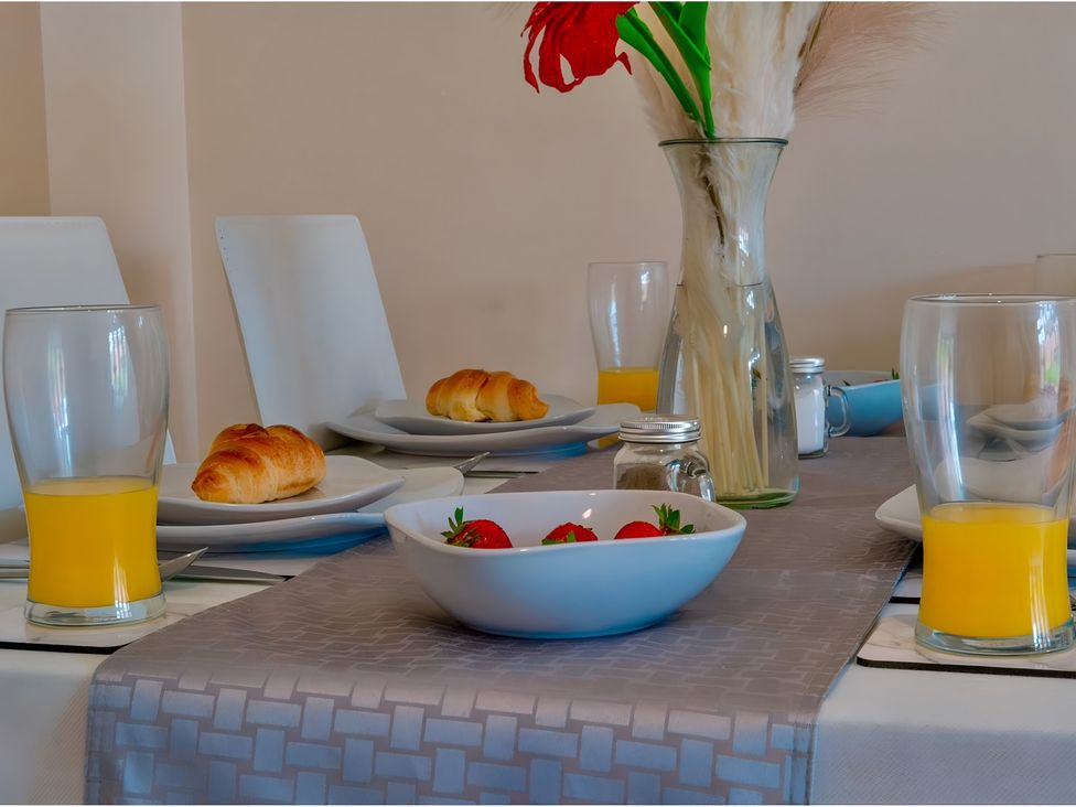 A dining room table set with croissants and strawberries at Rochester Road in Corby