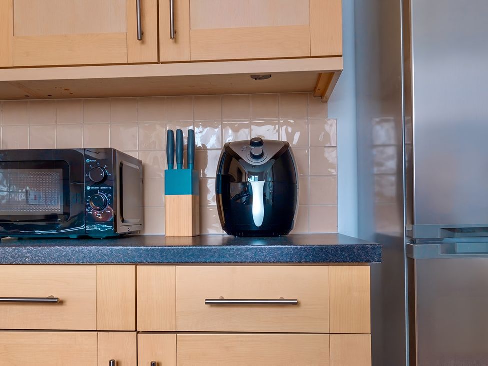 A kitchen with a microwave and air fryer on the counter at Rochester Road in Corby