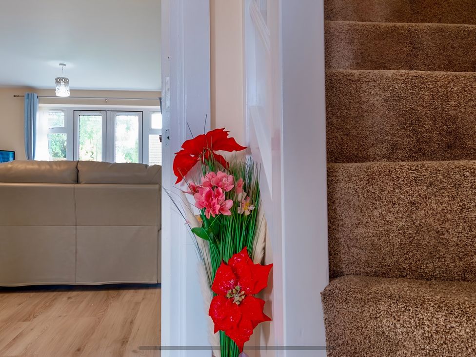 A living room with a sofa and decorative flowers at Rochester Road in Corby
