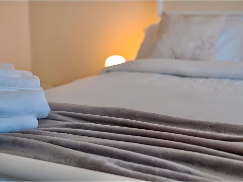 A bedroom with towels and a blanket at Rochester Road in Corby