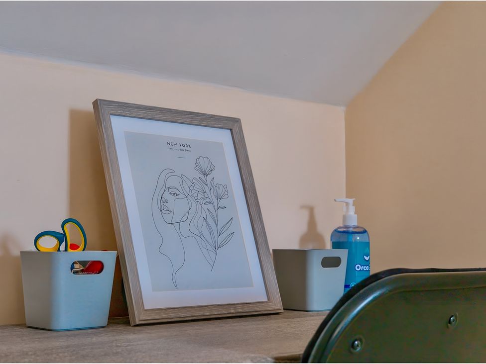 An office desk with an art print and storage boxes at Rochester Road in Corby