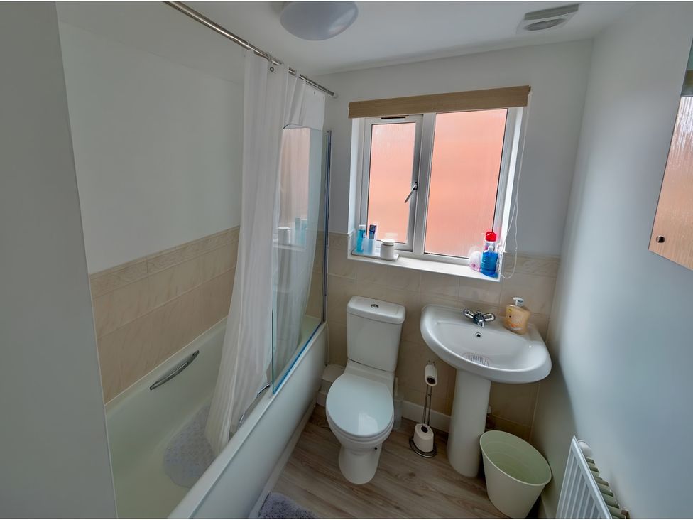 A bathroom with a bath tub and a sink at Rochester Road in Corby