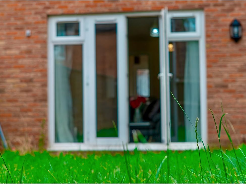 A garden with glass doors leading to a living area at Rochester Road in Corby