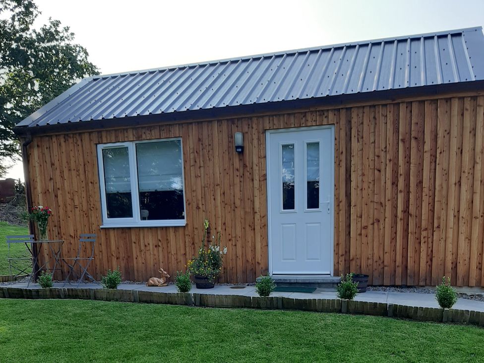 An outdoor view of a wooden building with a door and window at Taigh Nam Moireach Inverness