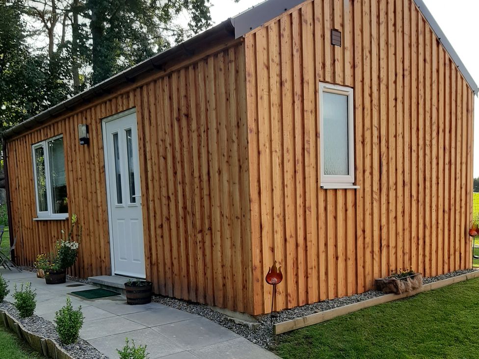 A wooden exterior of a house with a pathway and planters at Taigh Nam Moireach in Inverness
