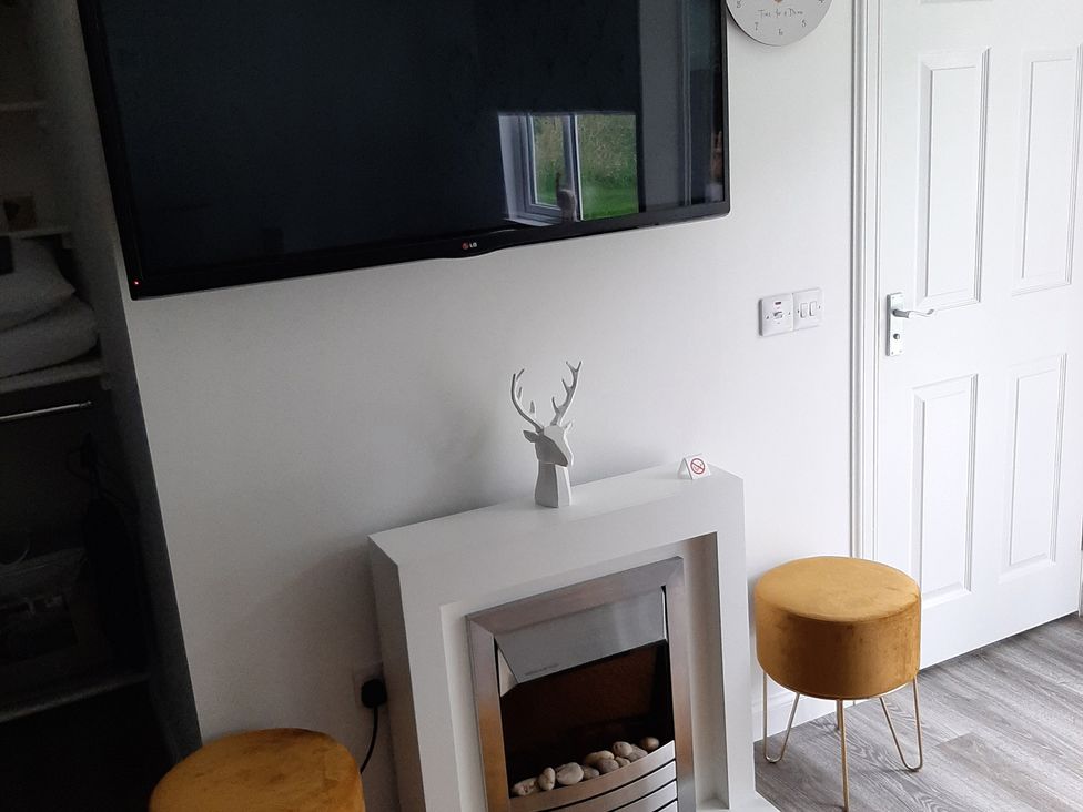 A living room with a fireplace and television at Taigh Nam Moireach in Inverness