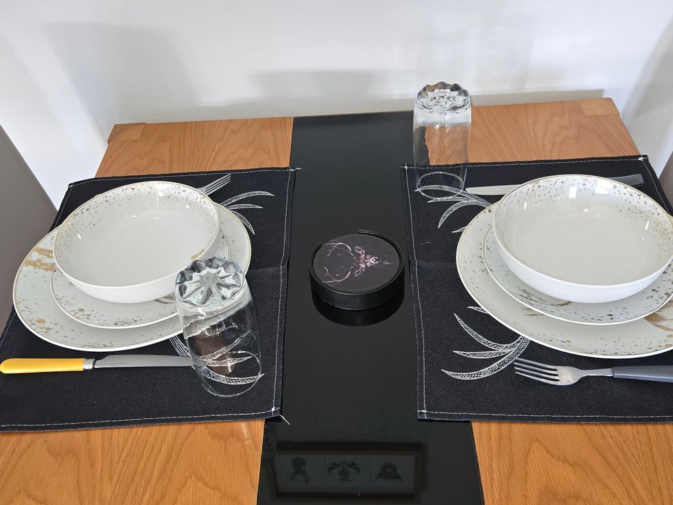 A dining table set with plates, bowls, and cutlery at Taigh Nam Moireach in Inverness