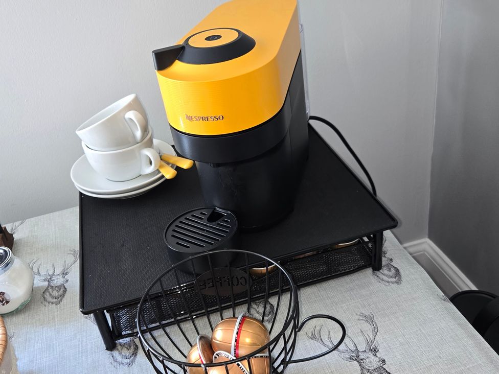 A coffee maker with cups and pods at Taigh Nam Moireach in Inverness