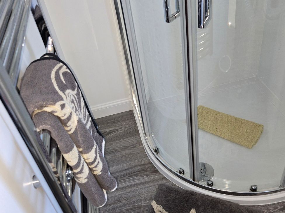 A bathroom with a towel and shower at Taigh Nam Moireach in Inverness